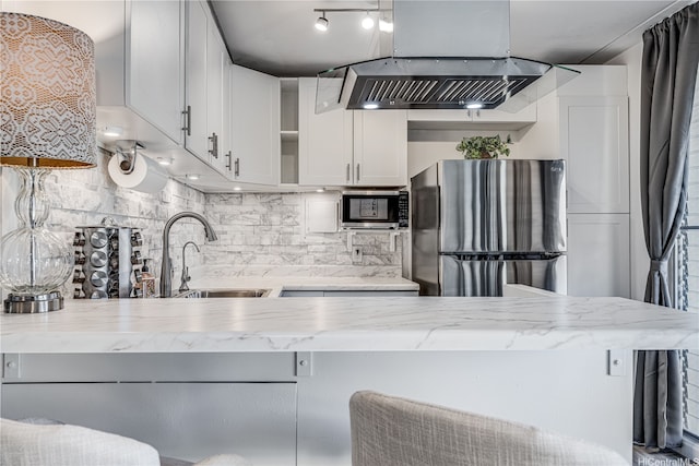 1002 S Kihei Rd Unit 205, Kihei, HI 96753 - kitchen featuring appliances with stainless steel finishes, a sink, island range hood, light stone countertops, and decorative backsplash