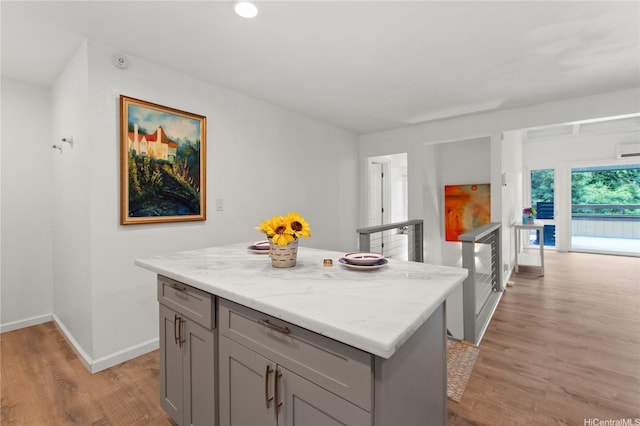 47-730 Hui Kelu St Unit 4404, Kaneohe, HI 96744 - kitchen featuring gray cabinetry, light wood-style floors, baseboards, a center island, and light stone counters