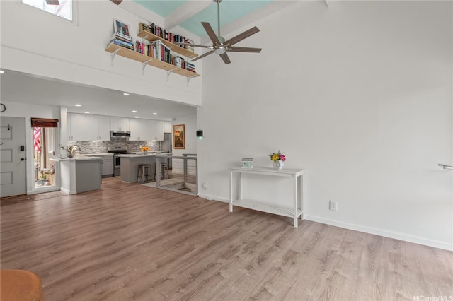 47-730 Hui Kelu St Unit 4404, Kaneohe, HI 96744 - living area with a ceiling fan, light wood finished floors, beamed ceiling, a high ceiling, and baseboards