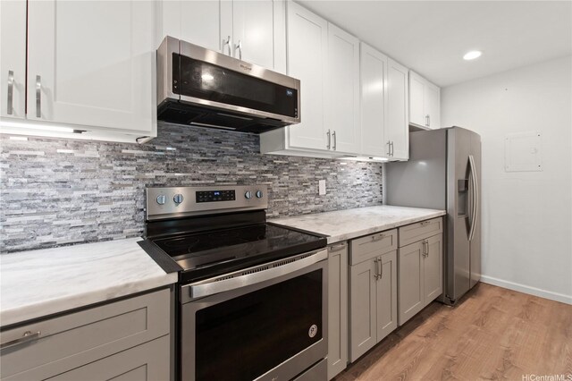 47-730 Hui Kelu St Unit 4404, Kaneohe, HI 96744 - kitchen featuring appliances with stainless steel finishes, light wood-style floors, decorative backsplash, white cabinetry, and recessed lighting