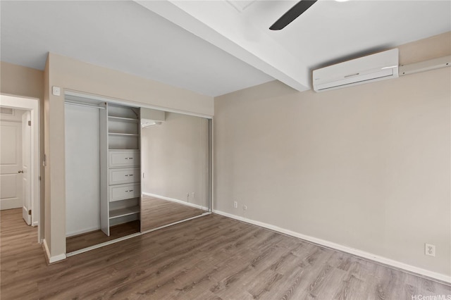 47-730 Hui Kelu St Unit 4404, Kaneohe, HI 96744 - unfurnished bedroom with an AC wall unit, wood finished floors, a closet, and baseboards