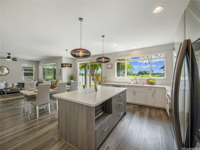 91-5408 Kapolei Pkwy Unit 37, Kapolei, HI 96707 - kitchen with appliances with stainless steel finishes, open floor plan, light countertops, a kitchen island, and dark wood-type flooring