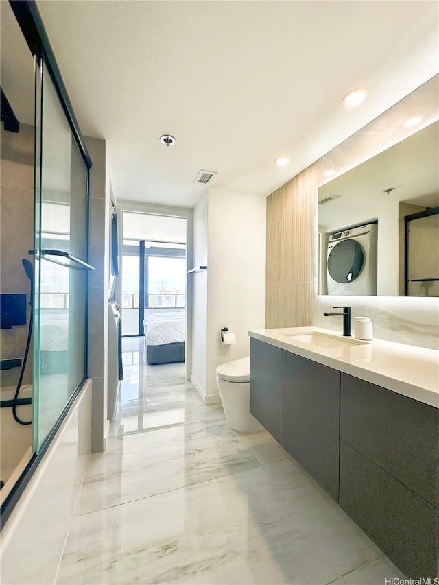581 Kamoku St Unit 3906, Honolulu, HI 96826 - full bath featuring stacked washer / dryer, recessed lighting, vanity, toilet, and marble finish floors