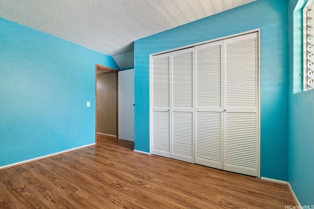98-1369 Koaheahe Pl Unit 989, Pearl City, HI 96782 - unfurnished bedroom featuring a closet, wood finished floors, baseboards, and a textured ceiling
