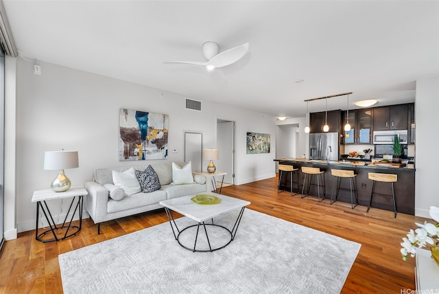 1189 Waimanu St Unit 3305, Honolulu, HI 96814 - living room with light wood-type flooring, ceiling fan, and baseboards