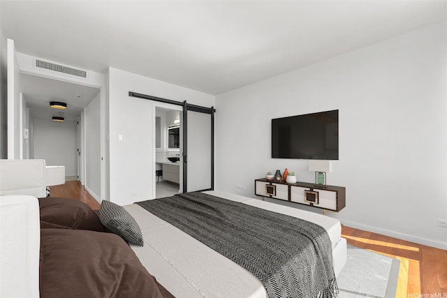 4340 Pahoa Ave Unit 7B, Honolulu, HI 96816 - bedroom with a barn door, wood finished floors, and baseboards