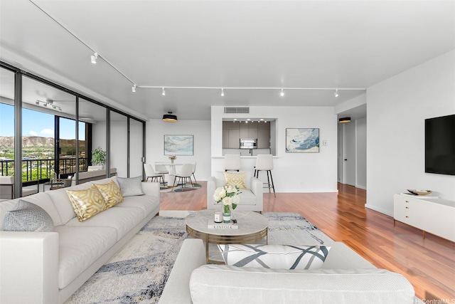 4340 Pahoa Ave Unit 7B, Honolulu, HI 96816 - living area featuring wood finished floors, rail lighting, and baseboards