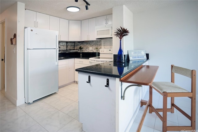 2724 Kahoaloha Ln Unit 902, Honolulu, HI 96826 - kitchen with white appliances, a peninsula, white cabinets, a textured ceiling, and decorative backsplash