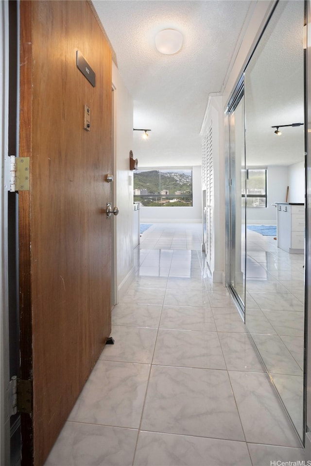 2724 Kahoaloha Ln Unit 902, Honolulu, HI 96826 - corridor featuring plenty of natural light, baseboards, and light marble finish flooring