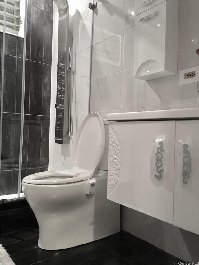 91-1708 Bond St, Ewa Beach, HI 96706 - bathroom featuring toilet, tile walls, a stall shower, and tile patterned floors