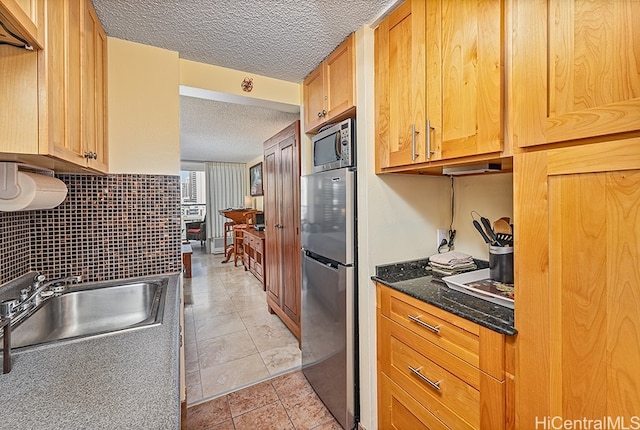 445 Seaside Ave Unit 1618, Honolulu, HI 96815 - kitchen featuring a sink, appliances with stainless steel finishes, a textured ceiling, and dark stone counters