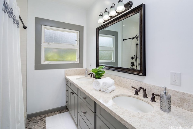 bathroom with double vanity and a tile shower