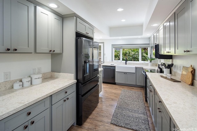 kitchen with black appliances, gray cabinetry, light wood-type flooring, and recessed lighting