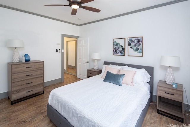 bedroom with crown molding, wood finished floors, and ceiling fan