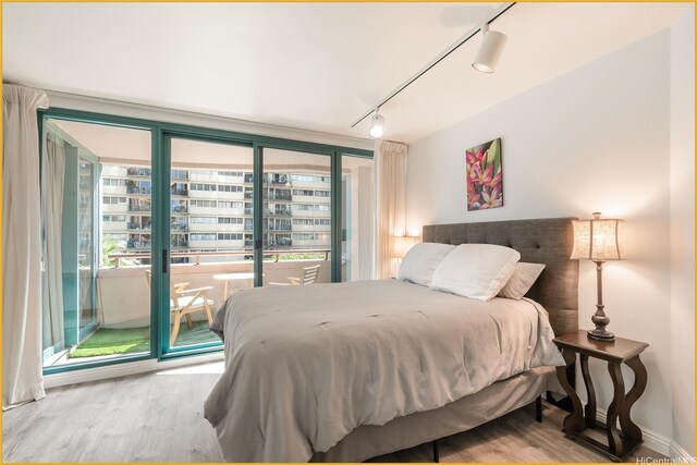 1888 Kalakaua Ave Unit 807, Honolulu, HI 96815 - bedroom with rail lighting, access to exterior, wood finished floors, and multiple windows