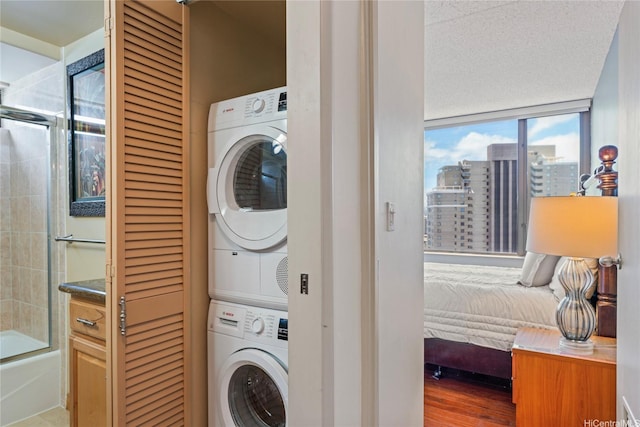 411 Hobron Ln Unit 3314, Honolulu, HI 96815 - washroom featuring stacked washing machine and dryer, a city view, and wood finished floors