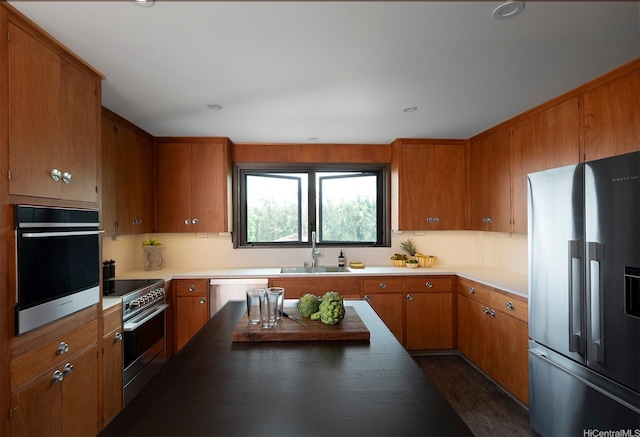 1875 Kualono St, Honolulu, HI 96817 - kitchen featuring appliances with stainless steel finishes, a sink, brown cabinets, and light countertops