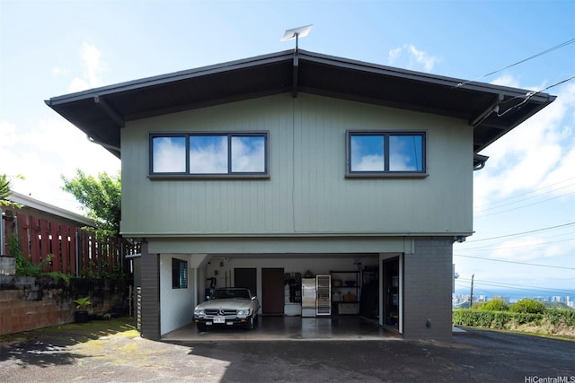 1875 Kualono St, Honolulu, HI 96817 - view of property exterior featuring a garage, brick siding, and driveway