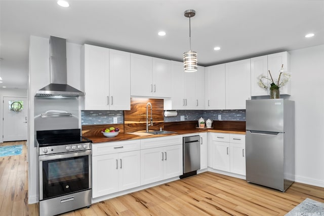 3657 Woodlawn Dr, Honolulu, HI 96822 - kitchen with appliances with stainless steel finishes, wall chimney range hood, butcher block countertops, light wood-style floors, and recessed lighting