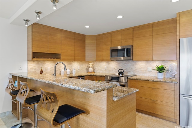389D Kaelepulu Dr Unit 1504, Kailua, HI 96734 - kitchen featuring stainless steel appliances, a peninsula, modern cabinets, light stone countertops, and recessed lighting