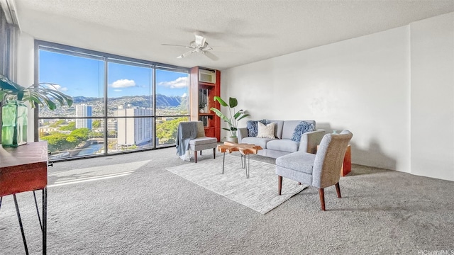 60 N Beretania St Unit 1702, Honolulu, HI 96817 - carpeted living room featuring a wall of windows, ceiling fan, a textured ceiling, a mountain view, and a wall mounted AC