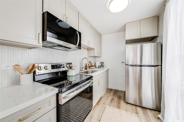 906 Lehua Ave Unit C301, Pearl City, HI 96782 - kitchen featuring stainless steel appliances, a sink, light wood-type flooring, tasteful backsplash, and light stone countertops