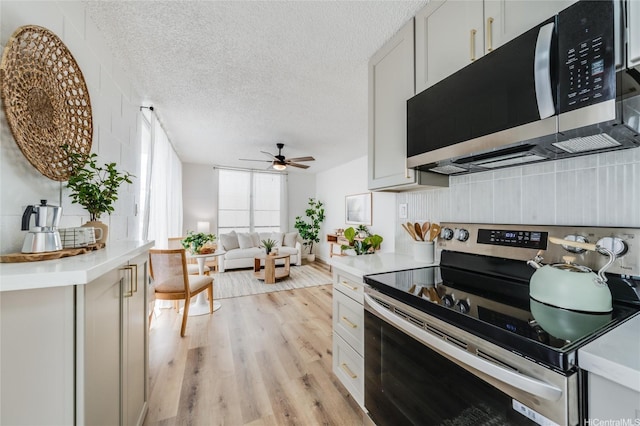 906 Lehua Ave Unit C301, Pearl City, HI 96782 - kitchen with electric stove, light countertops, ceiling fan, light wood finished floors, and a textured ceiling