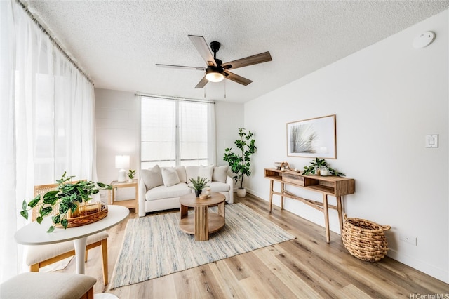 906 Lehua Ave Unit C301, Pearl City, HI 96782 - living area with a ceiling fan, a textured ceiling, wood finished floors, and baseboards
