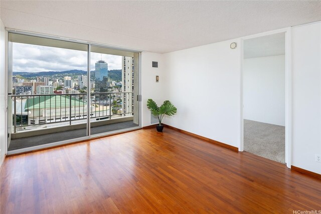 400 Hobron Ln Unit 2412, Honolulu, HI 96815 - spare room with expansive windows, wood finished floors, and a view of city