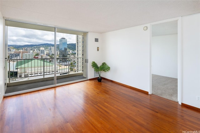 400 Hobron Ln Unit 2412, Honolulu, HI 96815 - empty room featuring floor to ceiling windows, wood finished floors, and a city view