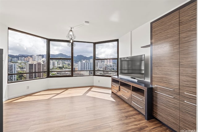 1221 Victoria St Unit 1705, Honolulu, HI 96814 - unfurnished living room featuring a city view, wood finished floors, and baseboards