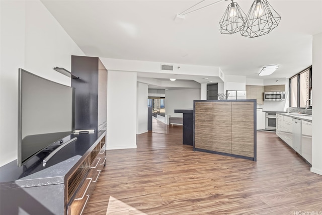 1221 Victoria St Unit 1705, Honolulu, HI 96814 - kitchen featuring stainless steel appliances, light wood-style floors, a chandelier, modern cabinets, and a sink