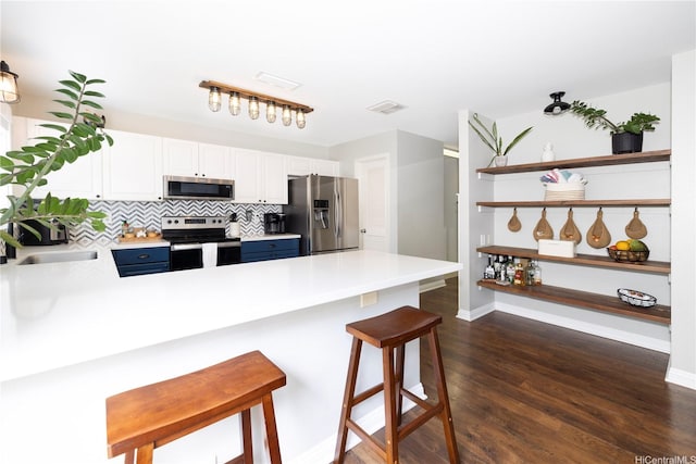 91-1013 Kailike St, Ewa Beach, HI 96706 - kitchen with stainless steel appliances, a peninsula, a breakfast bar, light countertops, and blue cabinets