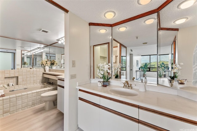 1525 Wilder Ave Unit 903, Honolulu, HI 96822 - full bath featuring wood finished floors, a garden tub, toilet, a textured ceiling, and vanity