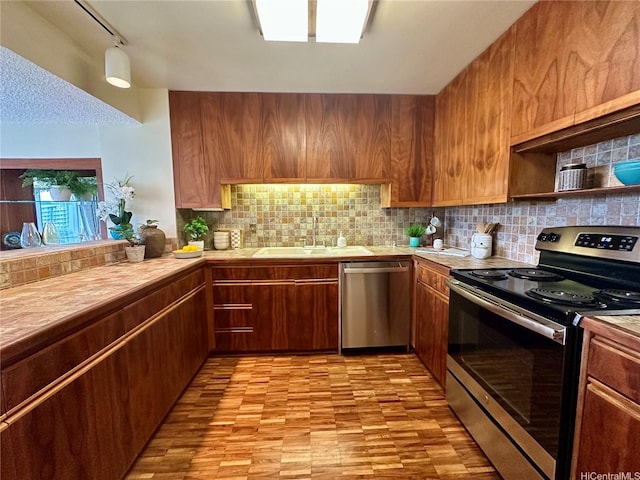 1525 Wilder Ave Unit 903, Honolulu, HI 96822 - kitchen with appliances with stainless steel finishes, a sink, decorative backsplash, tile counters, and brown cabinets