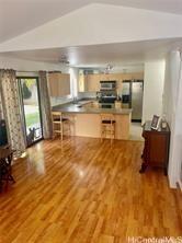 95-233 Halepule Pl Unit 44, Honolulu, HI 96789 - kitchen with vaulted ceiling, freestanding refrigerator, wood finished floors, a peninsula, and a kitchen breakfast bar