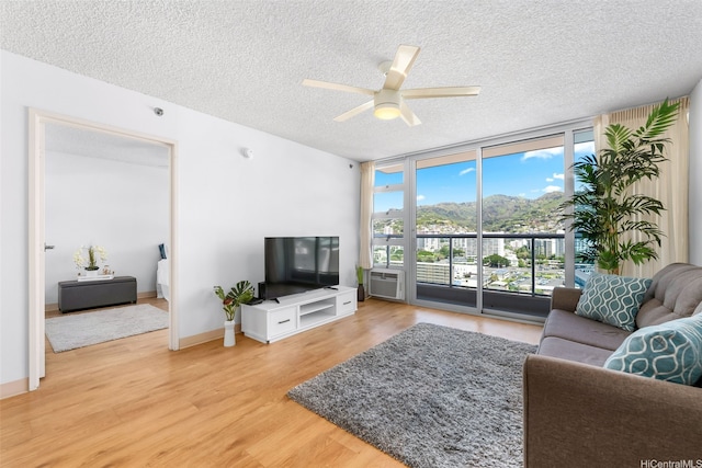 1450 Young St Unit 2004, Honolulu, HI 96814 - living area with floor to ceiling windows, a textured ceiling, light wood-type flooring, a ceiling fan, and baseboards