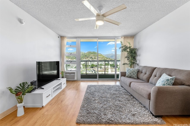 1450 Young St Unit 2004, Honolulu, HI 96814 - living room featuring floor to ceiling windows, a textured ceiling, light wood-style flooring, and ceiling fan