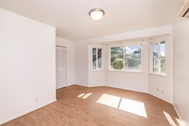 67-374 Haona St, Waialua, HI 96791 - unfurnished room featuring light wood-style flooring, an AC wall unit, and baseboards