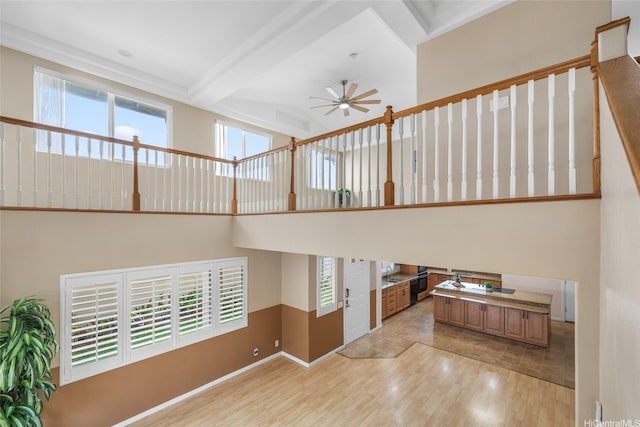 91-272 Kaieleele Pl, Ewa Beach, HI 96706 - unfurnished living room with light wood finished floors, ceiling fan, healthy amount of natural light, beamed ceiling, and baseboards