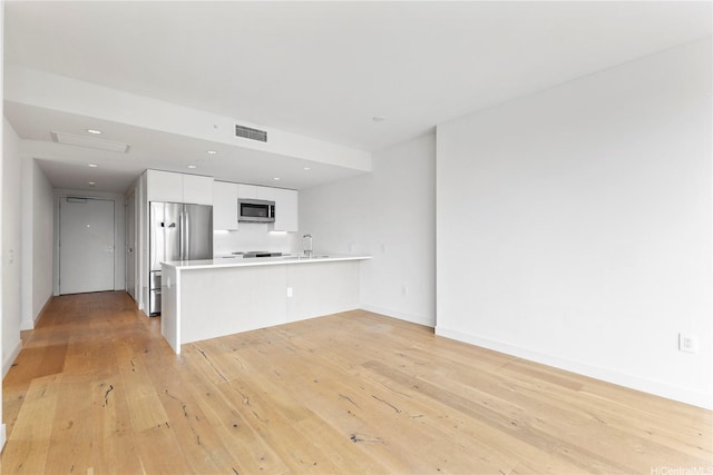 1001 Queen St Unit 1815, Honolulu, HI 96814 - kitchen featuring appliances with stainless steel finishes, a peninsula, white cabinets, light countertops, and a sink
