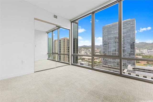 1001 Queen St Unit 1815, Honolulu, HI 96814 - empty room with a wall of windows, carpet floors, a city view, and a mountain view