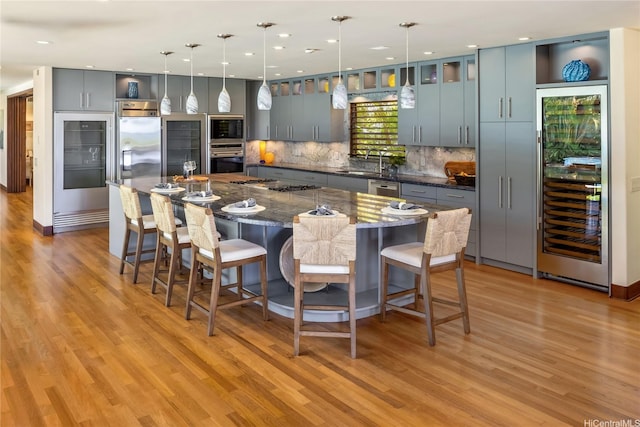 958 Mokulua Dr, Kailua, HI 96734 - kitchen with appliances with stainless steel finishes, beverage cooler, a sink, light wood finished floors, and recessed lighting