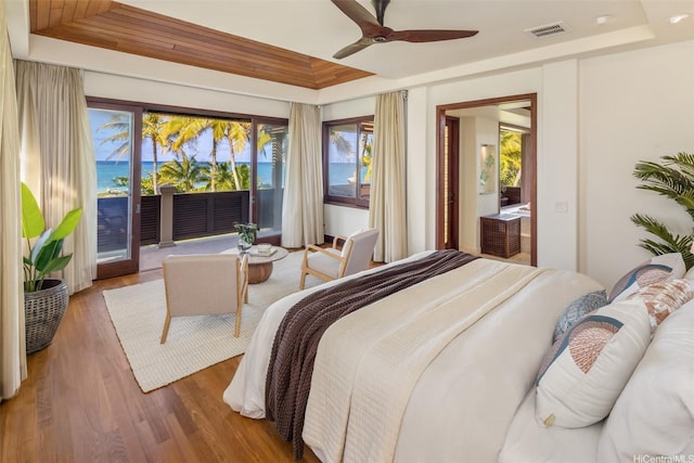 958 Mokulua Dr, Kailua, HI 96734 - bedroom featuring a tray ceiling, access to outside, multiple windows, and wood finished floors