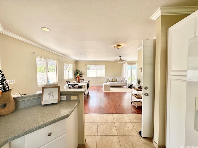 87-1976 Pakeke St Unit 5N, Waianae, HI 96792 - kitchen with crown molding, white cabinets, ceiling fan, and light tile patterned flooring