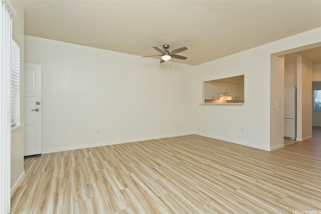 95-1030 Ainamakua Dr Unit 4, Mililani, HI 96789 - spare room featuring a ceiling fan, light wood-style flooring, a textured ceiling, and baseboards