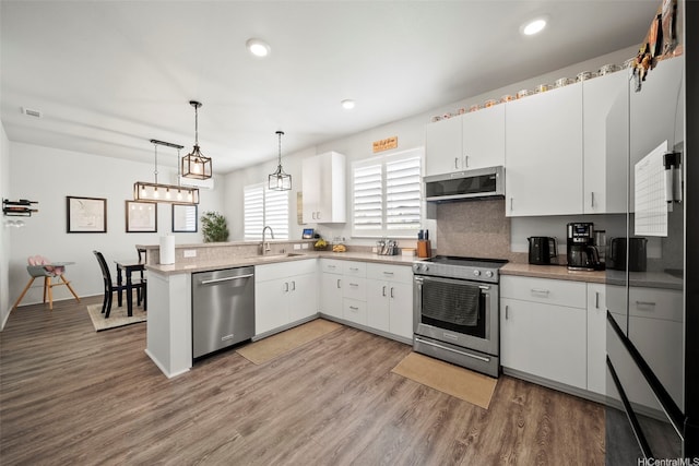91-1811 Kapeku Loop, Ewa Beach, HI 96706 - kitchen featuring appliances with stainless steel finishes, a peninsula, light wood-style flooring, white cabinetry, and recessed lighting