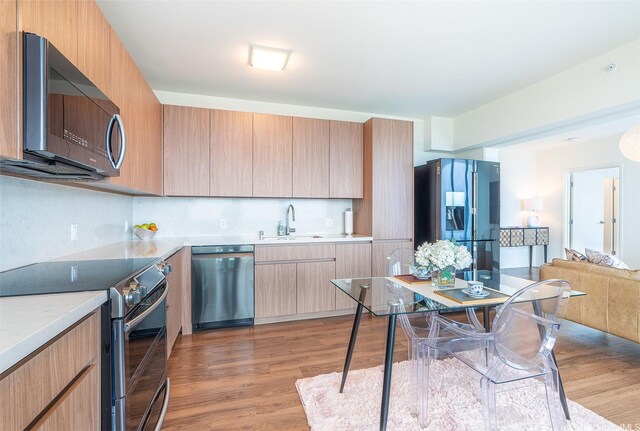 1391 Kapiolani Blvd Unit 4111, Honolulu, HI 96814 - kitchen featuring appliances with stainless steel finishes, a sink, light wood-type flooring, and light countertops