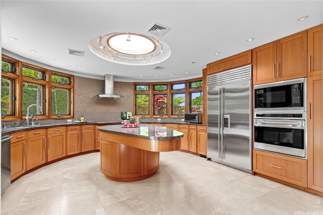 4498 Pahoa Ave, Honolulu, HI 96816 - kitchen featuring built in appliances, wall chimney exhaust hood, backsplash, dark stone countertops, and a center island