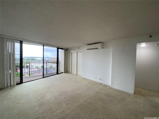 98-501 Koauka Loop Unit A1008, Aiea, HI 96701 - unfurnished room with a wall mounted air conditioner, a textured ceiling, carpet floors, and expansive windows